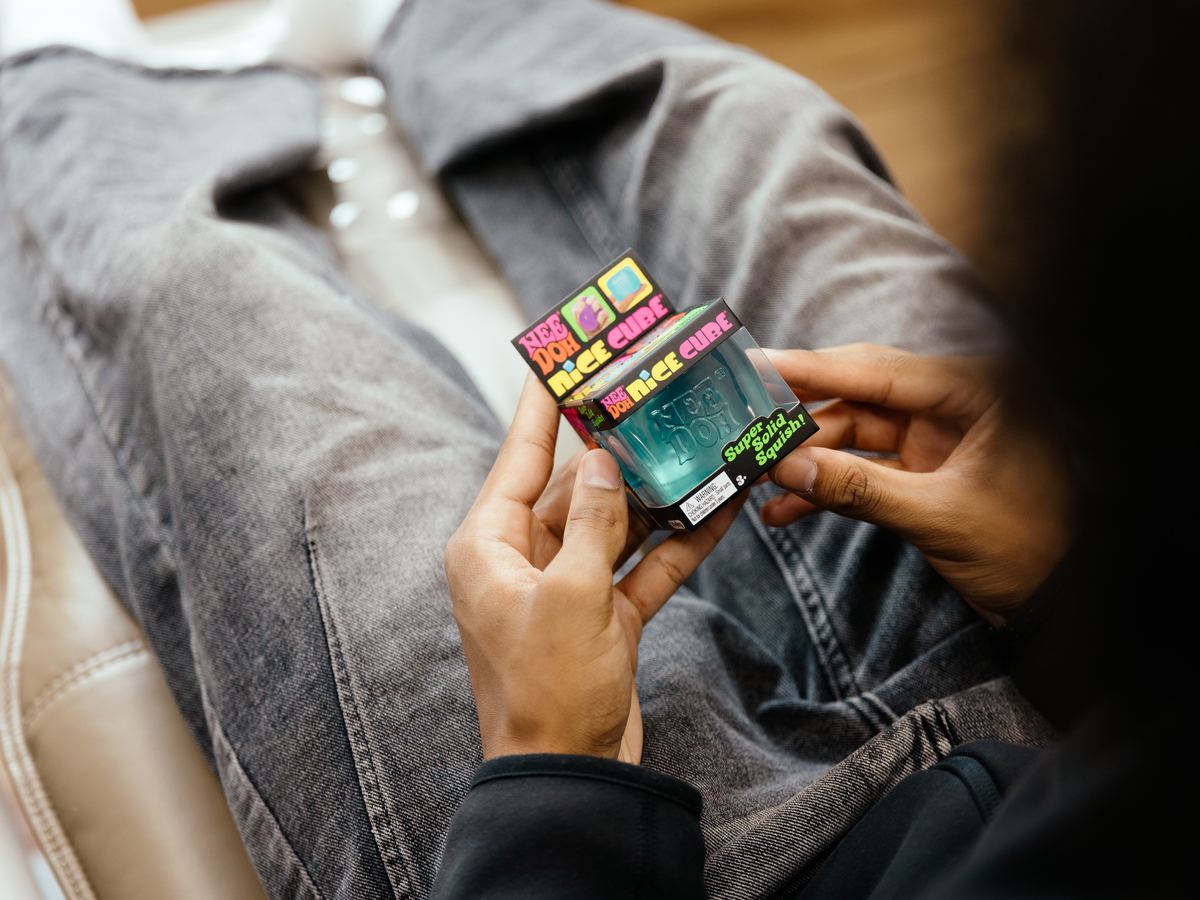 A patient holding a fidget cube during their visit