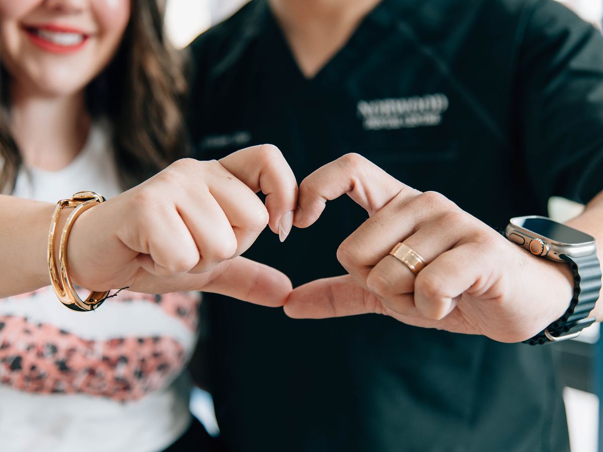 Two team members making a heart with their hands